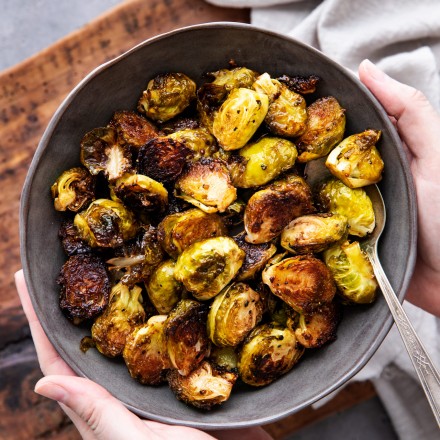 holding a bowl of roasted brussels sprouts