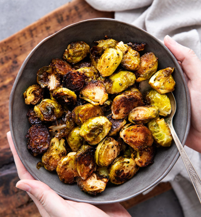 holding a bowl of roasted brussels sprouts