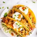 three chicken tacos on white plate