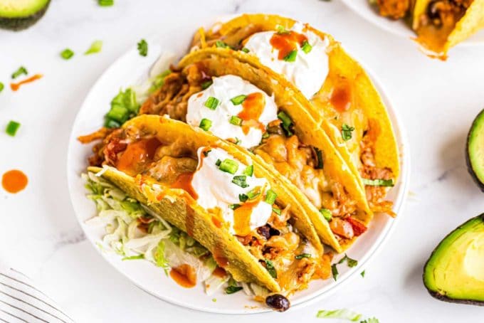 3 chicken tacos on white plate