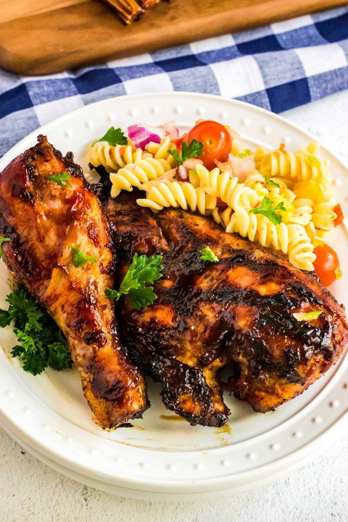 bbq chicken on white plate with pasta salad