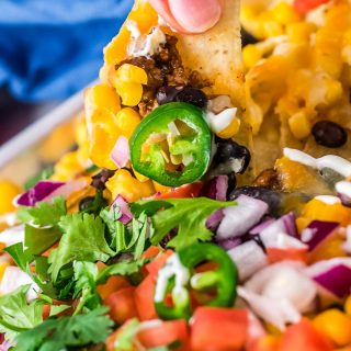 holding a loaded nacho from the sheet pan