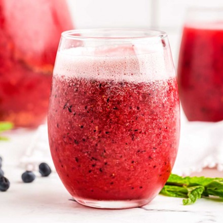 Glass of fruit punch with pitcher in the background