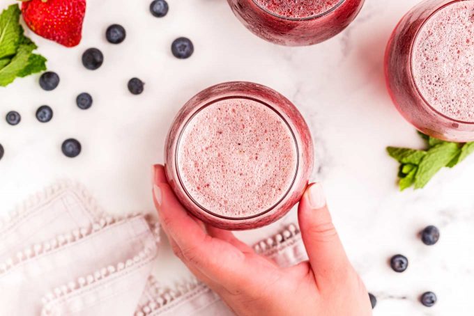 holding a glass of fizzy fruit punch