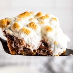 This ooey-gooey Caramel S'mores Cookie Cake has a buttery graham cracker/sugar cookie base, and is topped with melted chocolate and caramel, then topped with delicious toasted marshmallows!  It's the summer dessert you just can't resist!