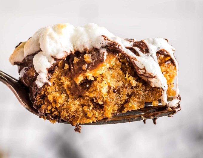 This ooey-gooey Caramel S'mores Cookie Cake has a buttery graham cracker/sugar cookie base, and is topped with melted chocolate and caramel, then topped with delicious toasted marshmallows!  It's the summer dessert you just can't resist!