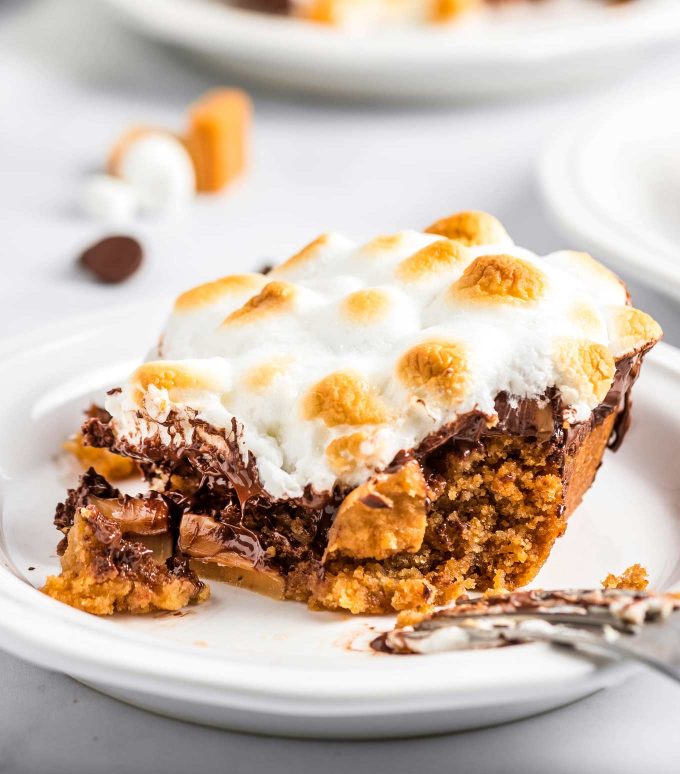 This ooey-gooey Caramel S'mores Cookie Cake has a buttery graham cracker/sugar cookie base, and is topped with melted chocolate and caramel, then topped with delicious toasted marshmallows!  It's the summer dessert you just can't resist!