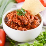 tomato salsa in white bowl with chip