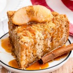 slice of apple cake on plate with caramel sauce