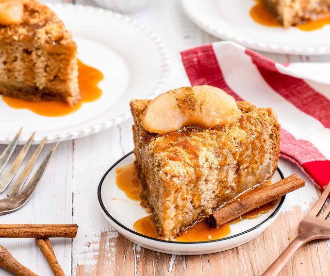 two pieces of cake on plates with caramel sauce on top