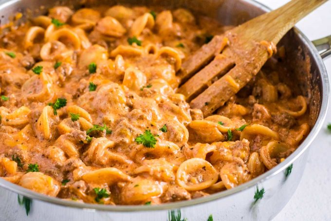 beef and shell pasta in stainless skillet