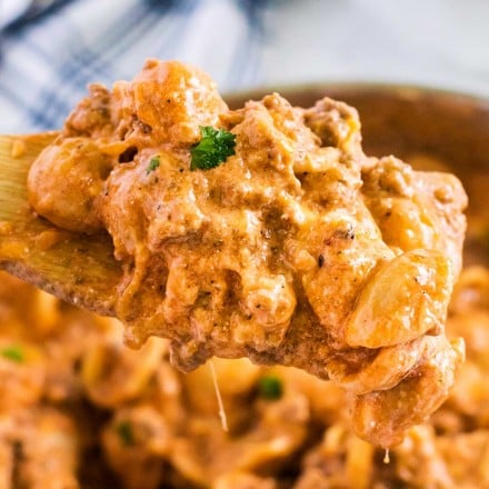 scoop of beef and shells pasta on wooden spoon