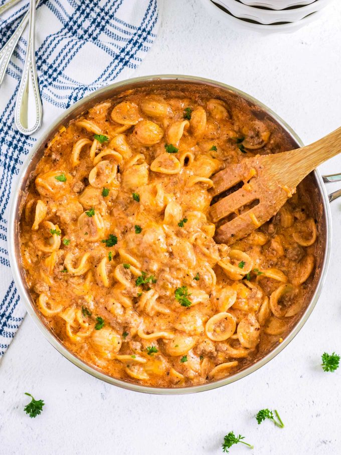 pan full of pasta with wooden spoon