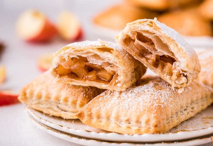 These homemade Apple Turnovers are filled with a spiced apple filling and baked in flaky, buttery puff pastry dough. Dust with powdered sugar or drizzle with glaze, and you have a breakfast that tastes like apple pie! #turnover #apple #applepie #applecinnamon #pastry #breakfast #dessert #baking