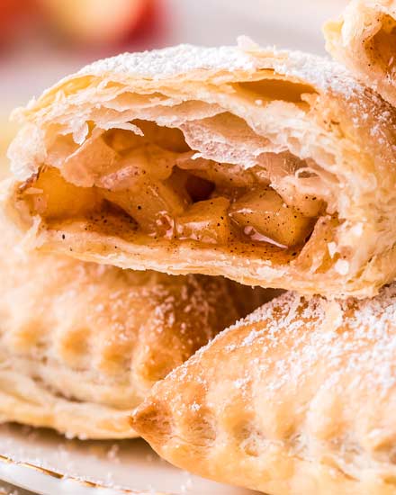 These homemade Apple Turnovers are filled with a spiced apple filling and baked in flaky, buttery puff pastry dough. Dust with powdered sugar or drizzle with glaze, and you have a breakfast that tastes like apple pie! #turnover #apple #applepie #applecinnamon #pastry #breakfast #dessert #baking