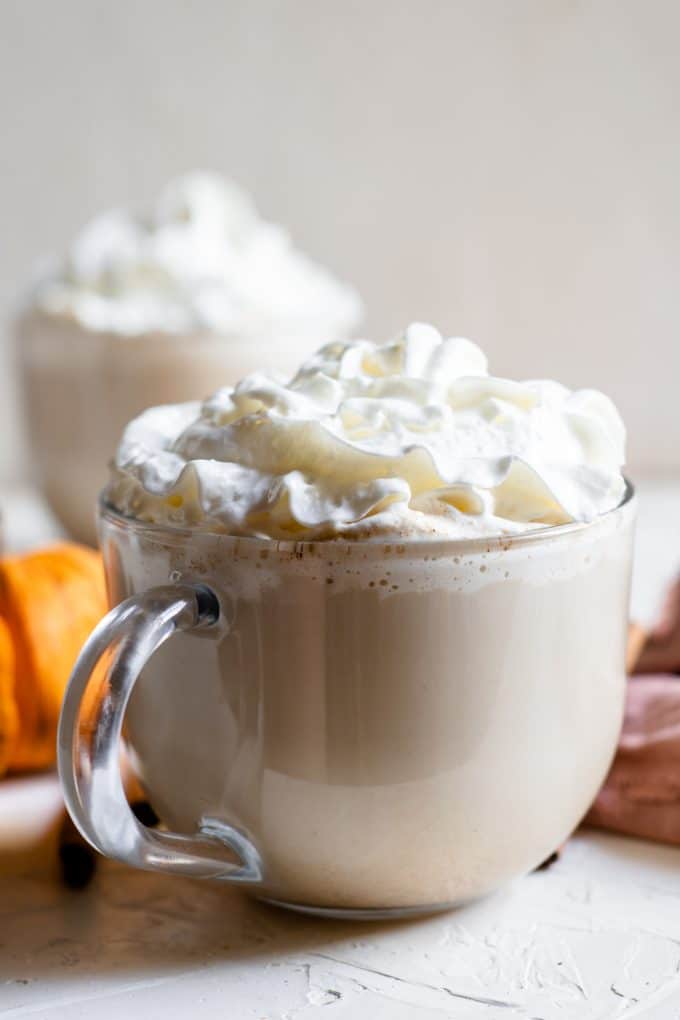 glass mug of pumpkin spice latte with whipped cream