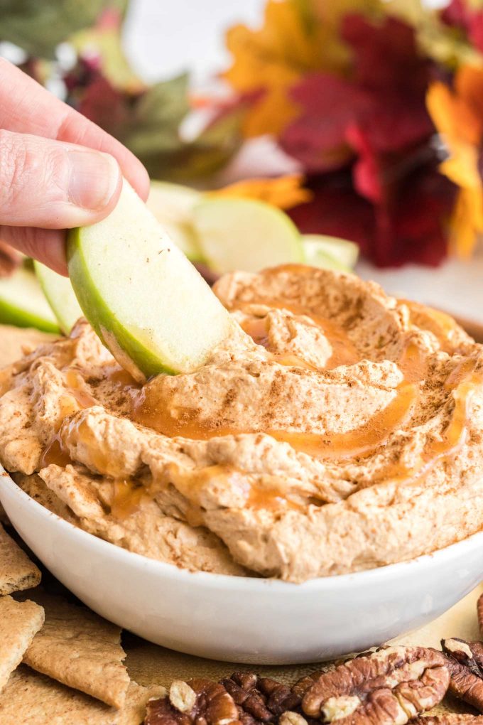 dipping an apple slice into dessert dip