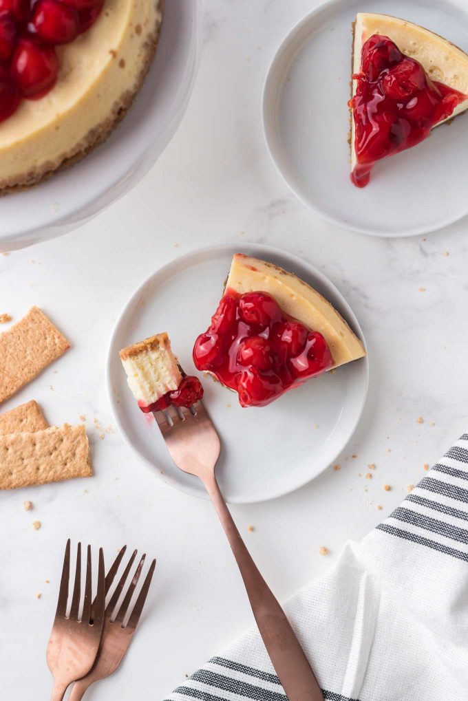 forkful of cheesecake topped with cherry pie filling