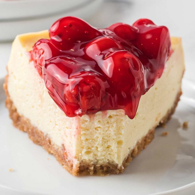 Slice of cheesecake topped with cherry pie filling