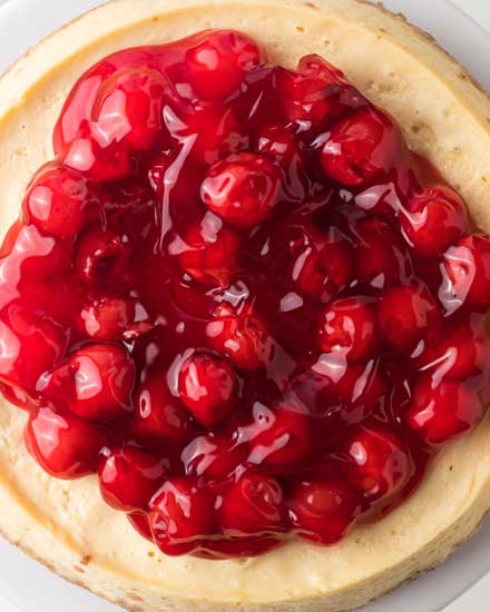 This easy Instant Pot Cheesecake is the perfect dessert recipe! Classic vanilla cheesecake comes out so creamy and rich, with a buttery graham cracker crust, and topped with classic cherry pie filling! #dessert #cheesecake #instantpot #pressurecooker #baking #easyrecipe #vanilla 