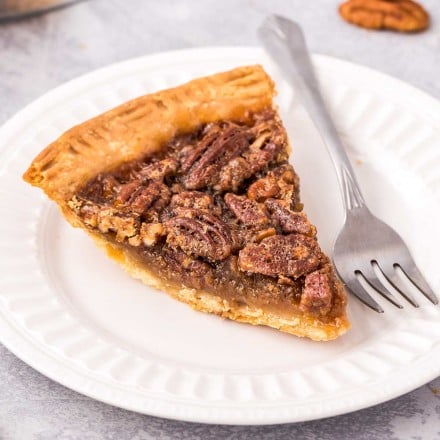slice of pecan pie on white plate with fork