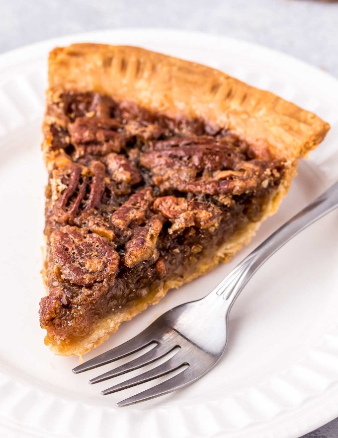 slice of pecan pie on white plate with fork