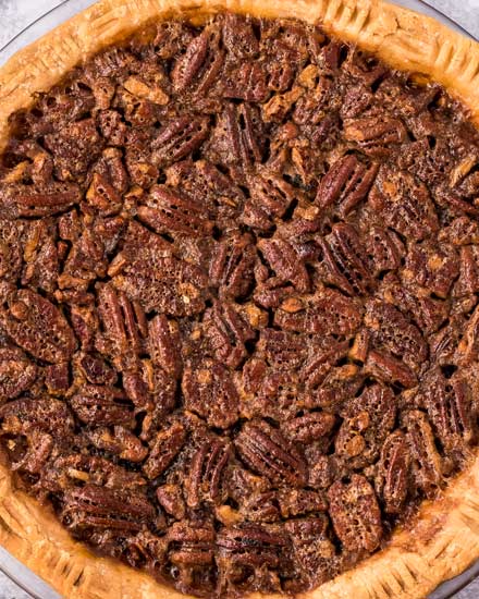 This Pecan Pie recipe is a classic Fall dessert, and a MUST for any Thanksgiving table.  Made with just a handful of simple ingredients, the gooey and sugary center, and the crisp nutty top make this the ultimate holiday dessert! #pecanpie #pie #pecan #thanksgiving #dessert #baking #holiday #holidaybaking #southern #homemadepie #fromscratch