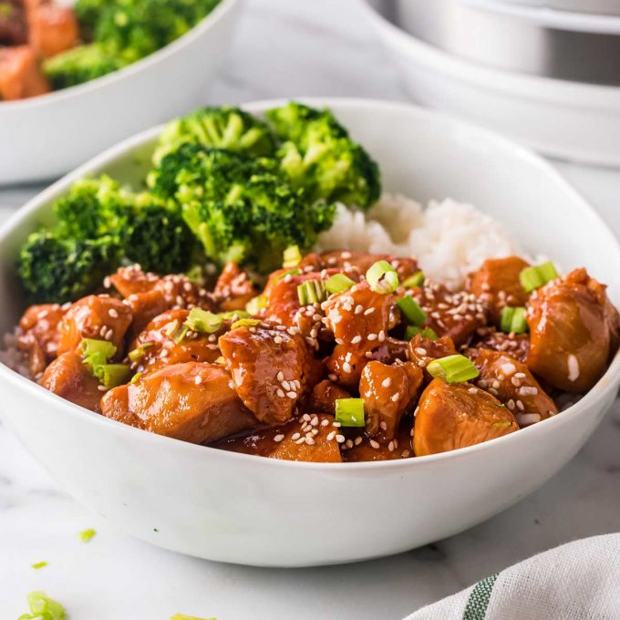 white bowl filled with rice, broccoli and sesame chicken