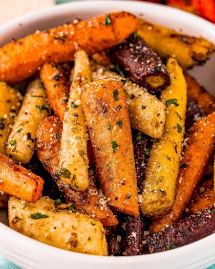 This classic Roasted Carrots recipe combines crisp fresh carrots, seasonings, garlic and Parmesan cheese, and bakes them until tender with lightly caramelized edges!  Savory with a natural sweetness from the carrots, it's the perfect side dish for the holidays or family dinner! #carrots #sidedish #vegetables #roasted #Parmesan #holiday #thanksgiving #easyrecipe #roastedveggies