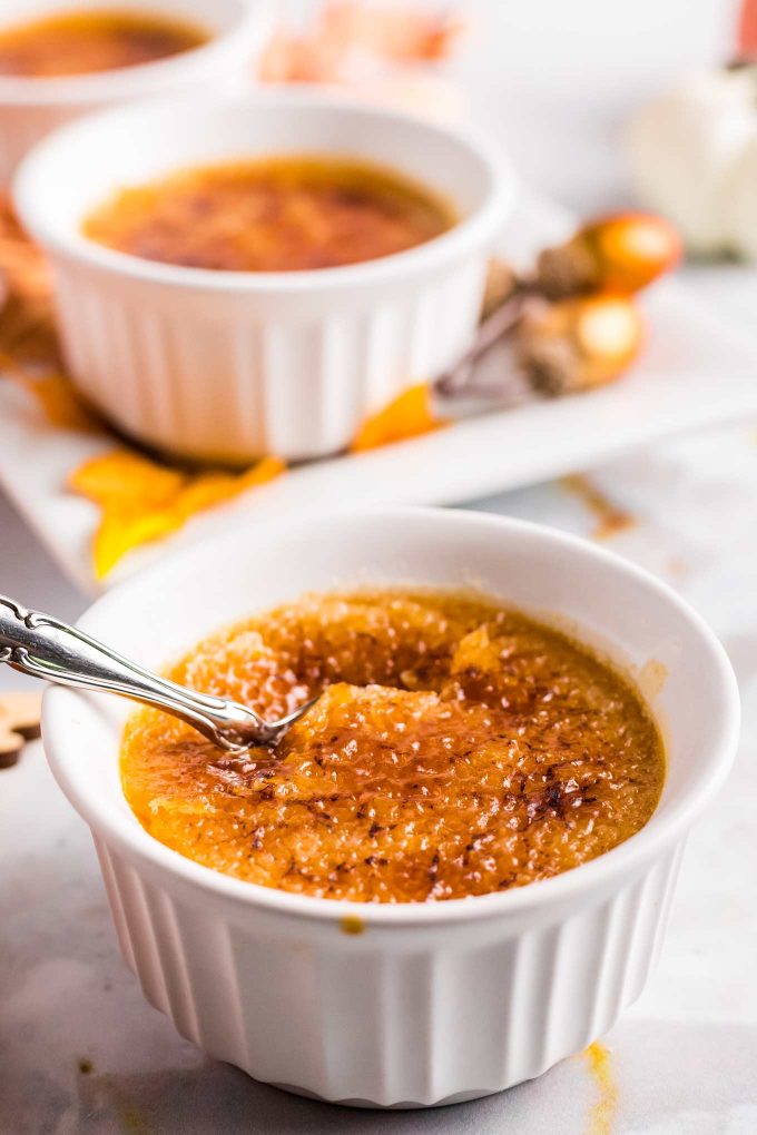 spoon cracking into sugar top of a creme brulee