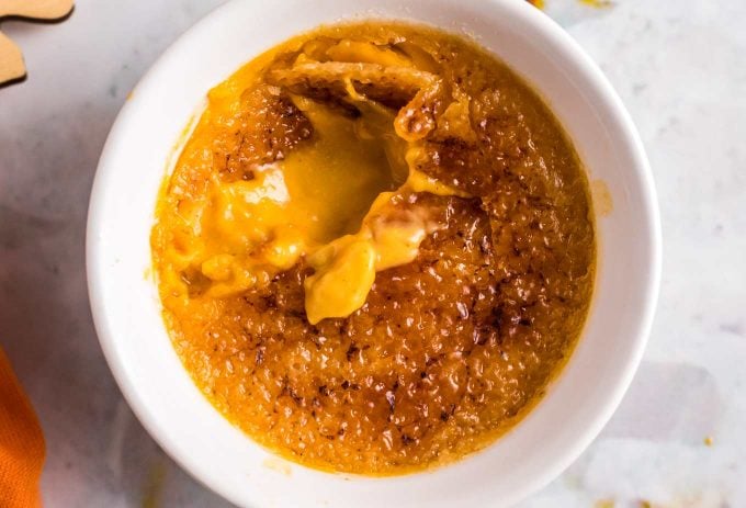 This Pumpkin Creme Brulee recipe is the perfect make-ahead fall dessert!  I promise it's easier to make than you think; just 5 simple ingredients give you a creamy custard topped with a crackly caramelized sugar topping! #cremebrulee #pumpkin #dessert #baking #makeahead #falldessert #fallbaking #custard