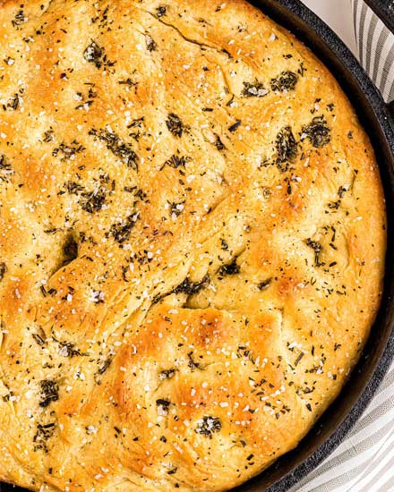 This easy focaccia recipe has a crispy crust, chewy middle, and plenty of herbs and salt in each bite!  With the option to let the dough rest for just a few hours, or overnight, this bread recipe is perfect for any dinner or party! #bread #focaccia #rosemary #seasalt #baking #yeast #baked #artisan #homemade
