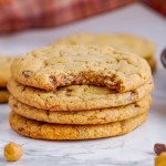 stack of pumpkin cookies, one with a bite taken out of it