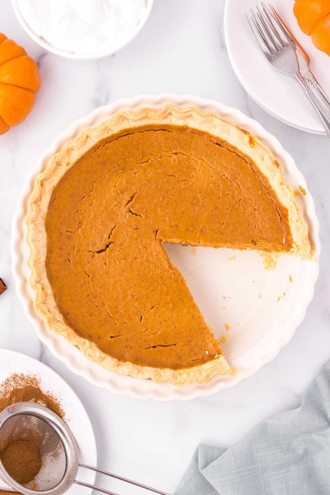 pumpkin pie in pie pan with slice taken out