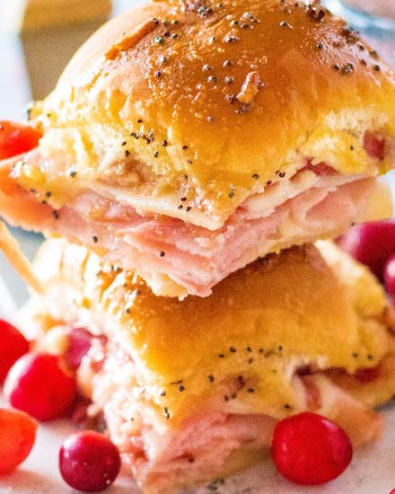 Looking for a great way to use up that leftover holiday ham? Try making these crowd pleasing Cranberry Ham Sliders!  Perfect with deli ham too, these quick and easy little Hawaiian roll sandwiches are a true family favorite! #ham #sliders #cranberry #leftovers #holiday #thanksgiving #christmas #hawaiianrolls