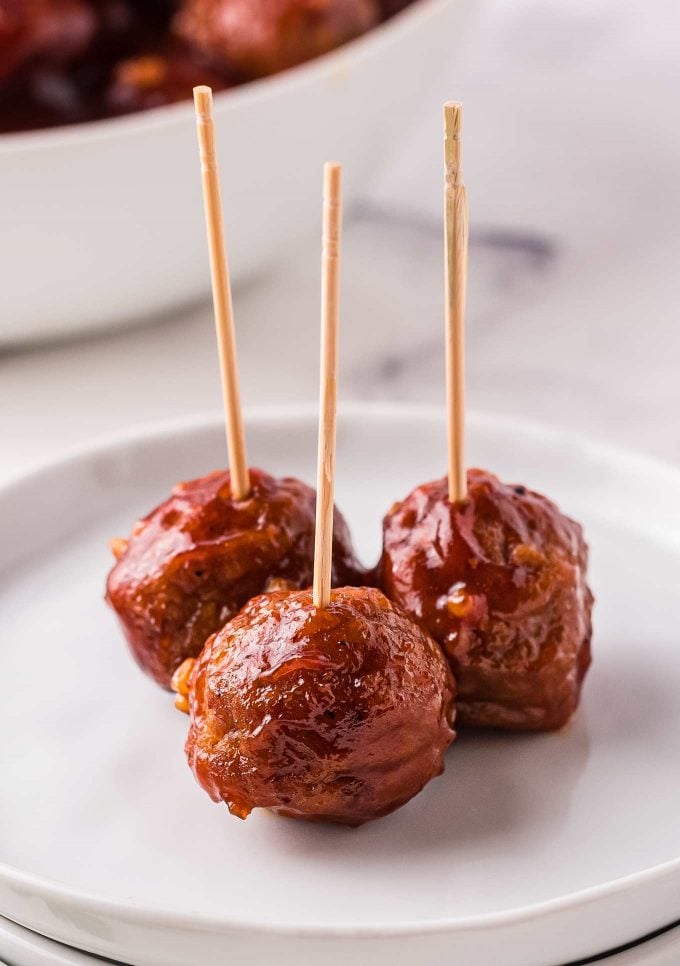 3 meatballs on white plate with toothpicks