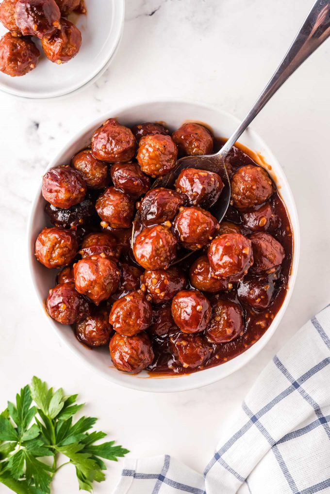 These crowd-pleasing tender meatballs are smothered in a super flavorful honey garlic bbq sauce.  Perfect for parties, this crockpot meatball recipe couldn't be more simple to make! #meatballs #crockpot #slowcooker #honeygarlic #bbq #appetizer #party #honey #garlic #easyrecipe