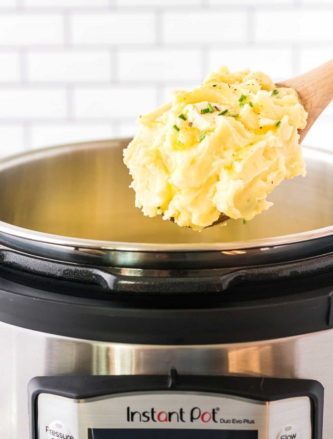 scoop of potatoes above an instant pot