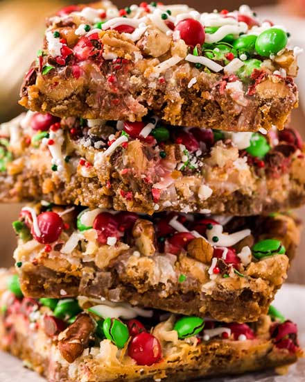 These easy Christmas 7 Layer Bars are great to make for the holidays!  Literally layer upon layer of deliciousness, this classic dessert goes by many names, such as magic cookie bars, hello dolly bars, etc... but no matter what you call them, they'll be a crowd-pleasing dessert! #7layerbars #magiccookiebars #hellodolly #kitchensink #sevenlayerbars #cookiebars #dessert #baking #holiday #christmas