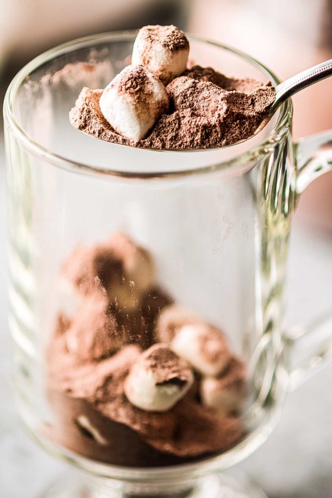 scooping hot chocolate mix into a mug