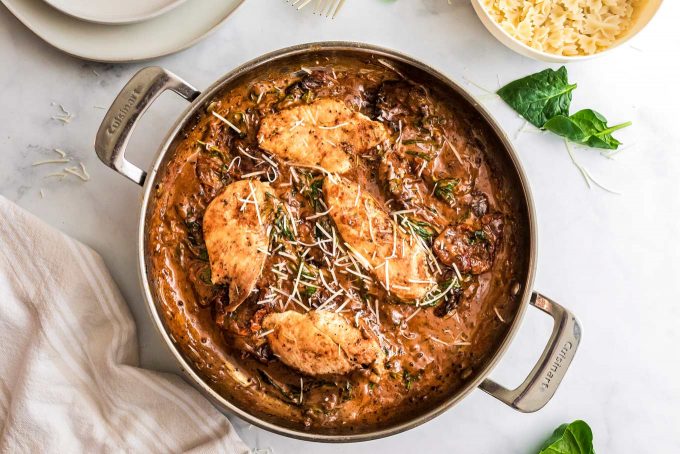 This One Pan Tuscan Chicken is a quick and easy one-pot meal that's sure to be a family favorite!  Juicy chicken, a creamy sauce made with bursts of sun dried tomatoes, Parmesan cheese and spinach, and it's ready in about 30 minutes, making it a great weeknight dinner option. #chicken #tuscan #Italian #chickenbreast #chickenrecipes #onepot #onepan #dinner #easyrecipe #30minutemeal