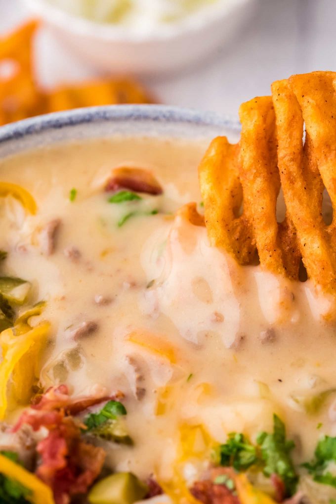 dipping a waffle fry into loaded cheeseburger soup