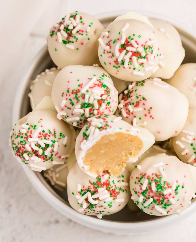 These Sugar Cookie Truffles are the perfect no-bake holiday dessert!  Using just 3 ingredients, plus some optional sprinkles, you can have these whipped up in no time! #truffles #sugarcookie #holidayrecipes #christmas #christmastruffles #dessertrecipe #easydessert #trufflerecipes #holidaytreatrecipes  #holiday #easyrecipe #christmasrecipe  #sugarcookietruffles #whitechocolate 