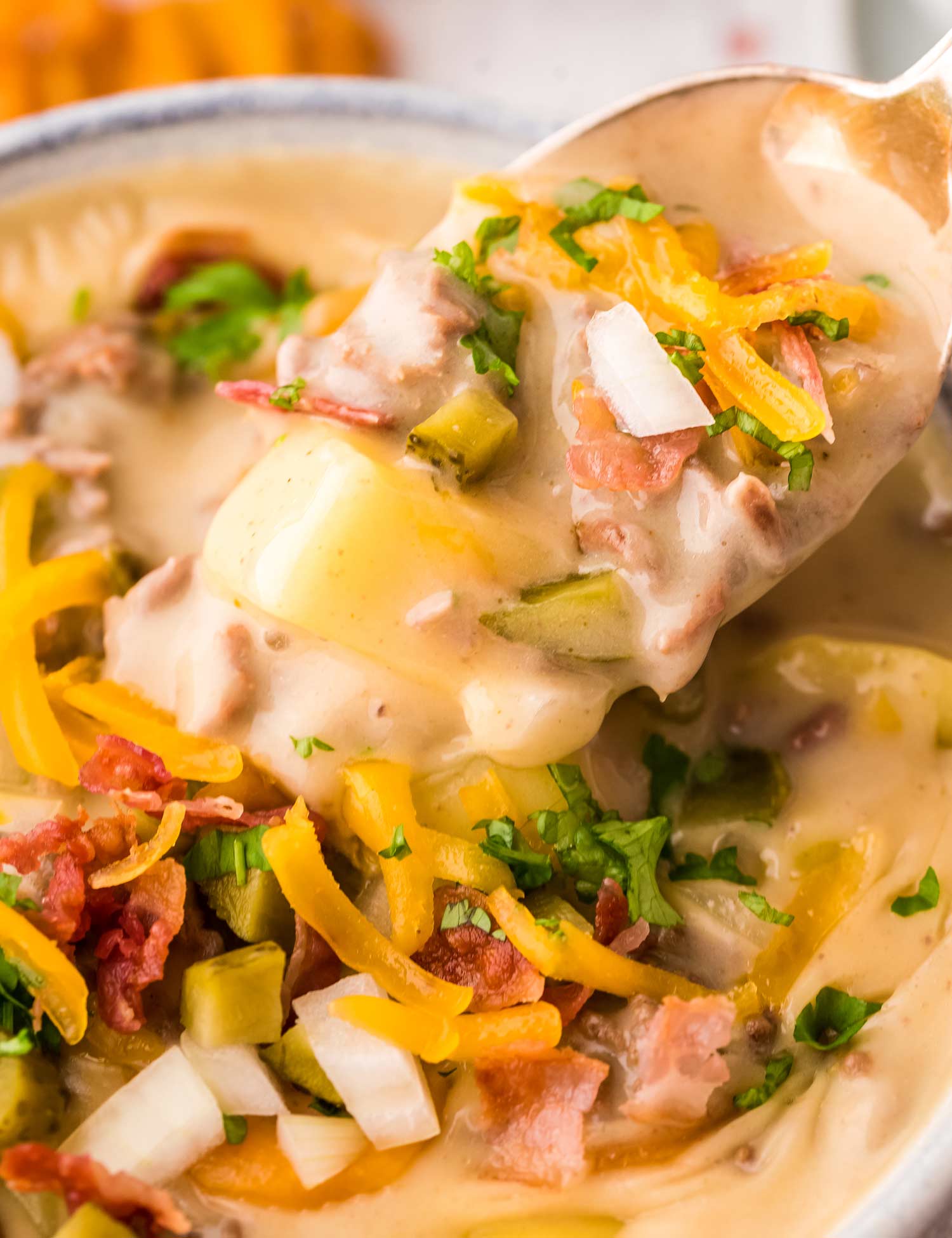 This easy Slow Cooker Cheeseburger Soup is SO delicious and sure to be a new family favorite dinner!  It’s classic American comfort food, in soul-warming soup form. #cheeseburgersoup #cheeseburger #soup #loadedcheeseburgersoup #cheesysoup #slowcooker #crockpot #beef