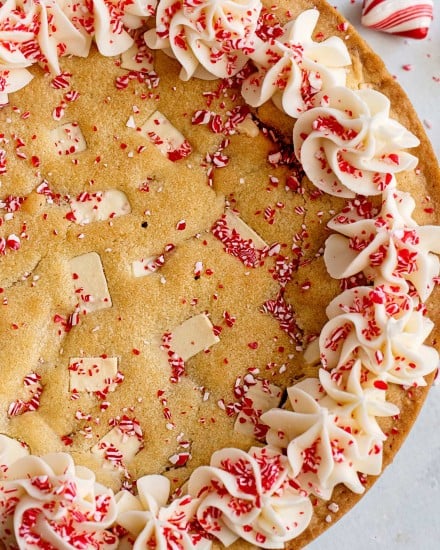 This Peppermint Sugar Cookie Cake is soft and chewy in the center, crisp around the edges, and filled with plenty of white chocolate/peppermint chunks.  The silky peppermint vanilla buttercream makes this a perfect holiday dessert! #sugarcookie #cookiecake #peppermint #whitechocolate #cookie #cake #holiday #dessert #dessertrecipe #easyrecipe #christmas #baking