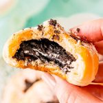 holding a fried oreo with a bite taken out of it