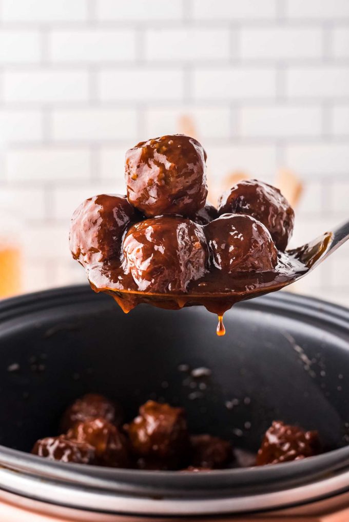 scooping some bbq meatballs out of the slow cooker