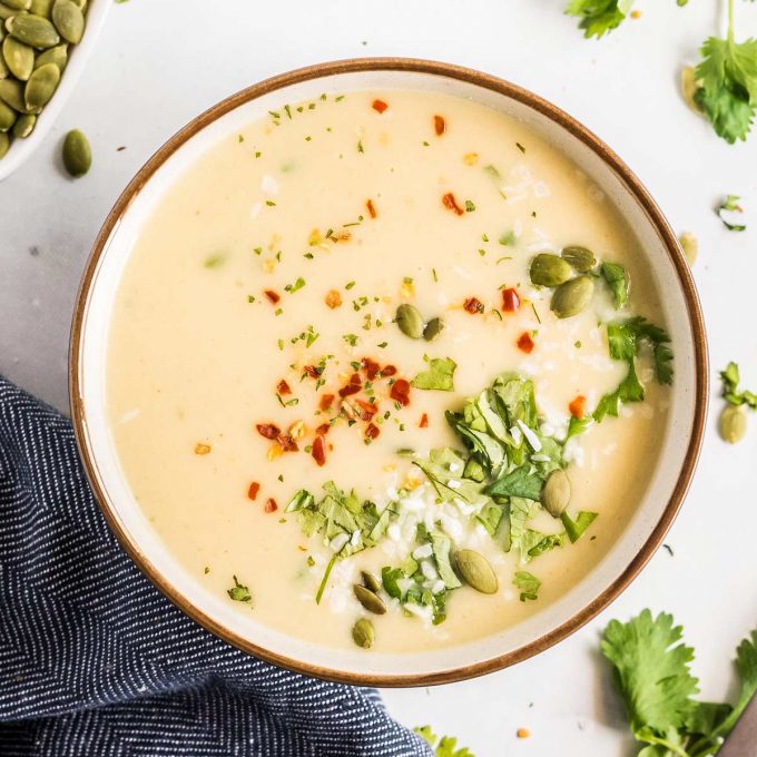 bowl of curry cauliflower soup with garnishes