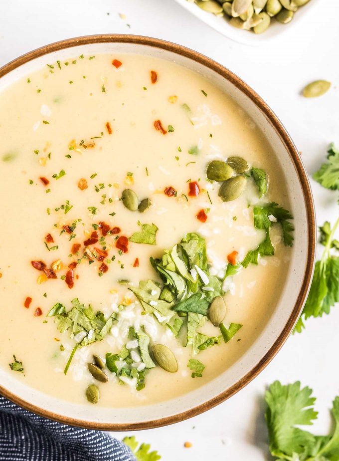 bowl of curried cauliflower soup with garnishes
