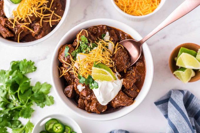 Texas-Style Chili recipe is thick and meaty, smoky and spicy.  This chili has no beans, but instead has a rich beefy gravy and chunks of seared beef that are slow simmered until perfectly tender. #texaschili #chili #nobeanchili #comfortfood #dutchoven #slowcooker